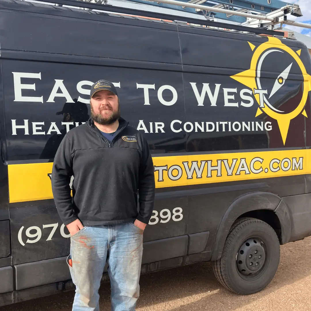 Nate Simond, Owner of East to West Heating and Air Conditioning, standing next to company truck