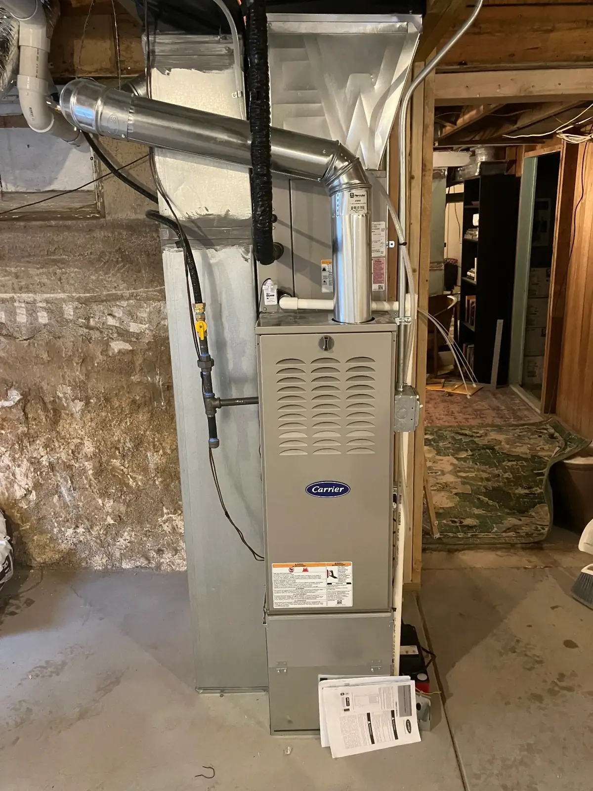 Complete Furnace Installation - Professional Carrier System Setup Complete Carrier furnace installation in basement showing professional workmanship, clean installation, and proper safety labeling